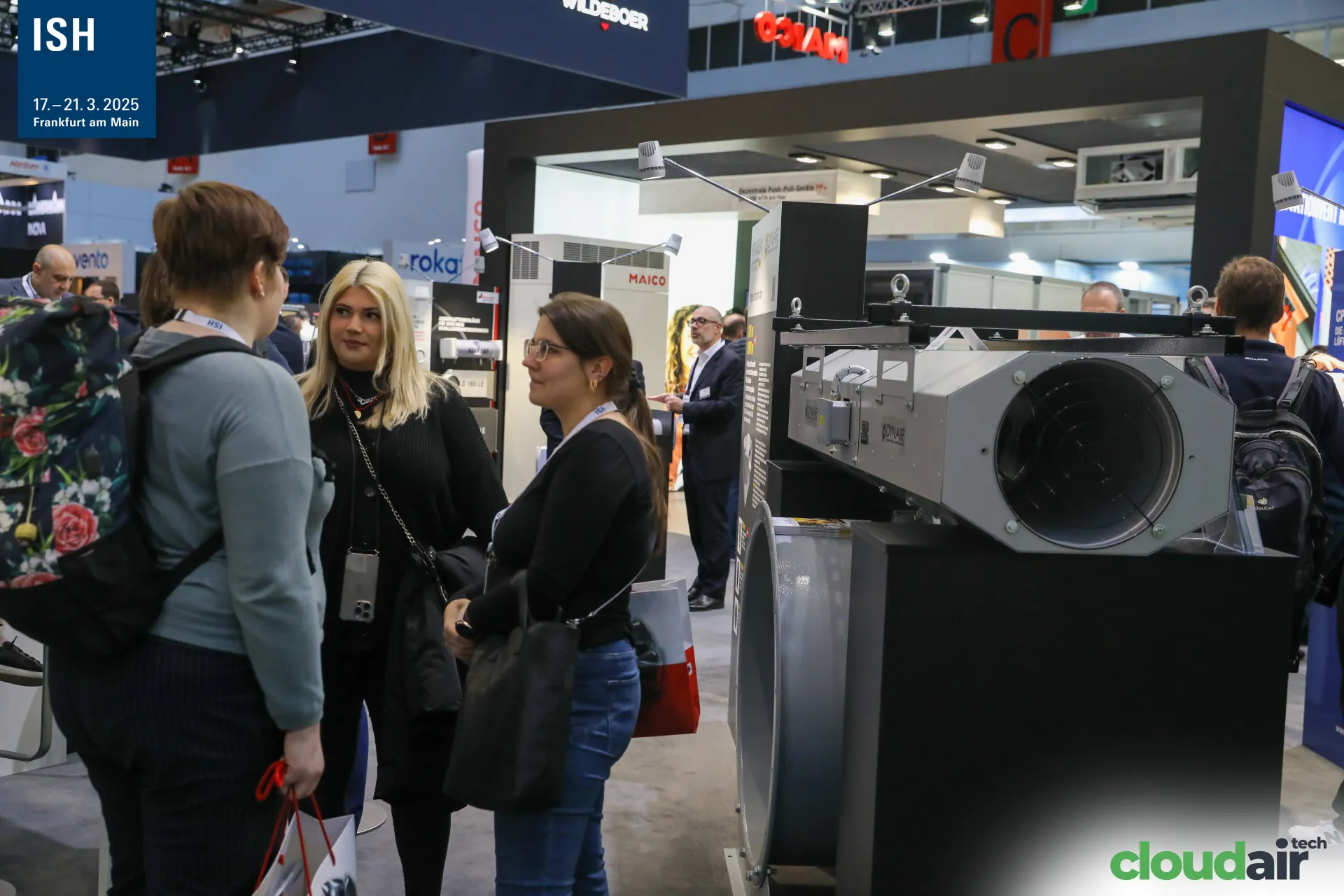 Visitors next to a Dynair jet fan and axial fan on the Maico stand at ISH 2025