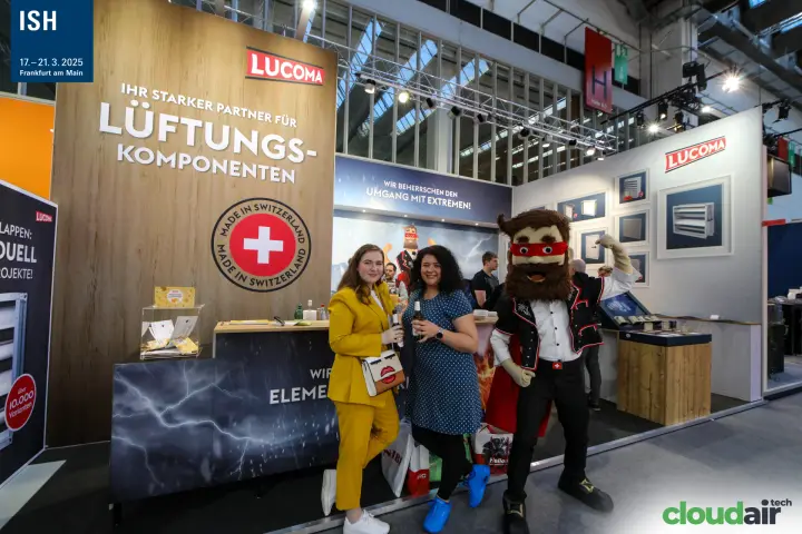 Visitors pose with the Lucoma superhero mascot at the counter at ISH 2025
