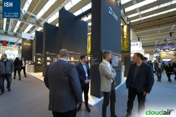 Visitors talk beside O.Erre black columns with VMC heat recovery units at ISH 2025
