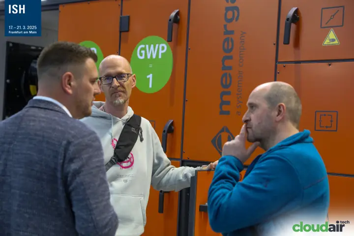 Visitors talking beside an orange Menerga unit marked GWP = 1