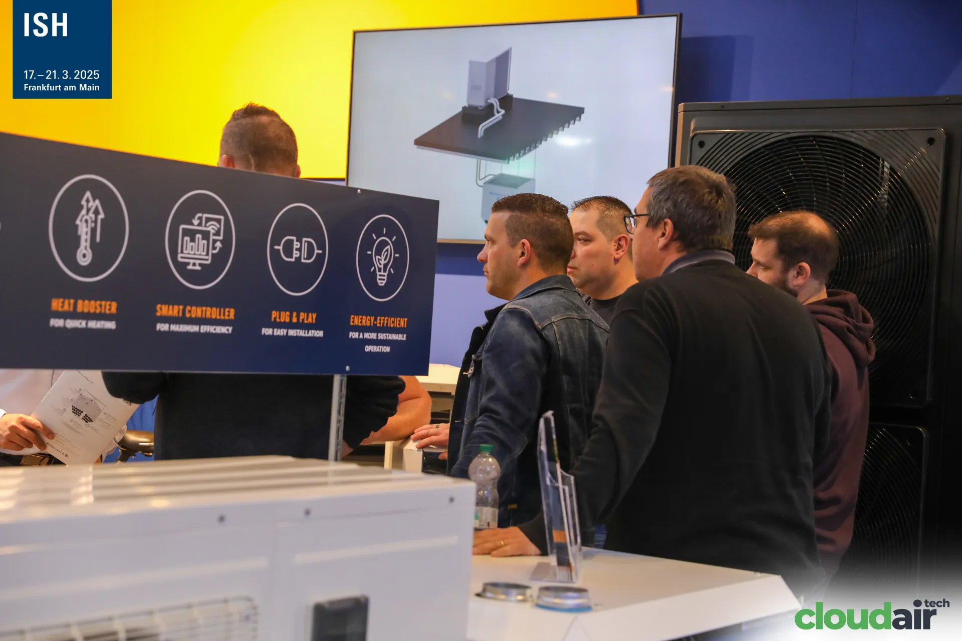 Visitors watch the Winterwarm Qwikshift animation beside a large outdoor unit at ISH 2025
