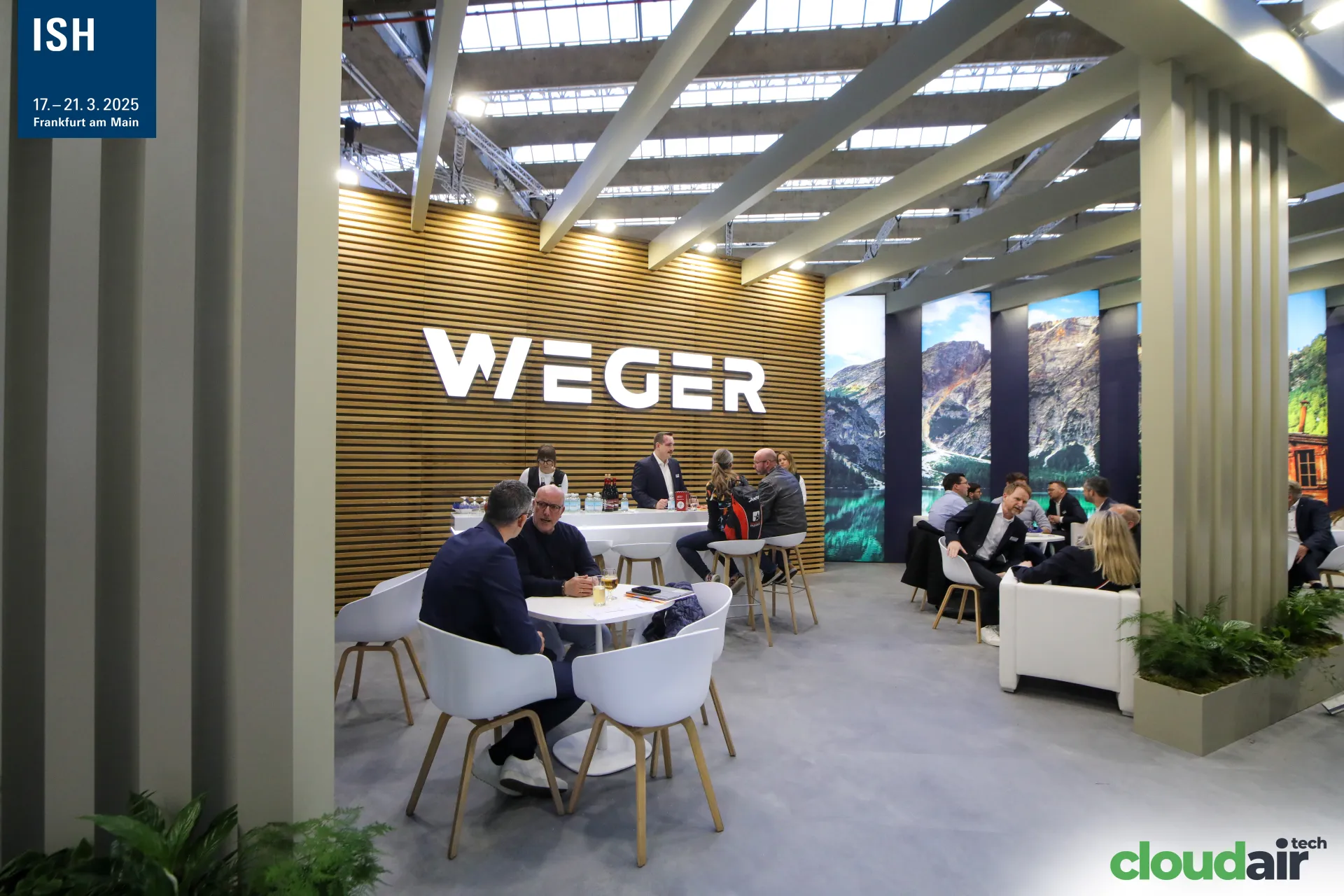Weger lounge and bar in front of a wooden slat wall with illuminated logo at ISH 2025