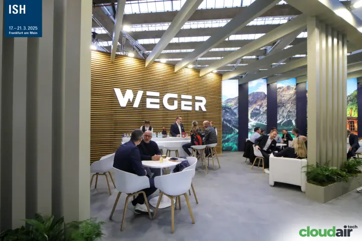Weger lounge and bar in front of a wooden slat wall with illuminated logo at ISH 2025