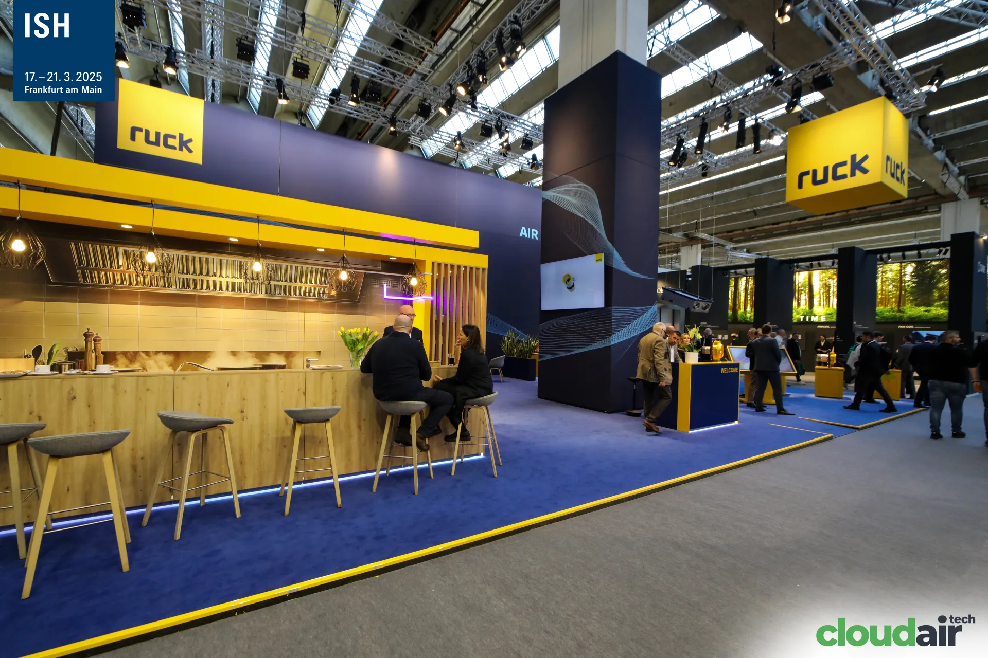 Wide view of the Ruck stand with kitchen-style bar and welcome desk at ISH 2025