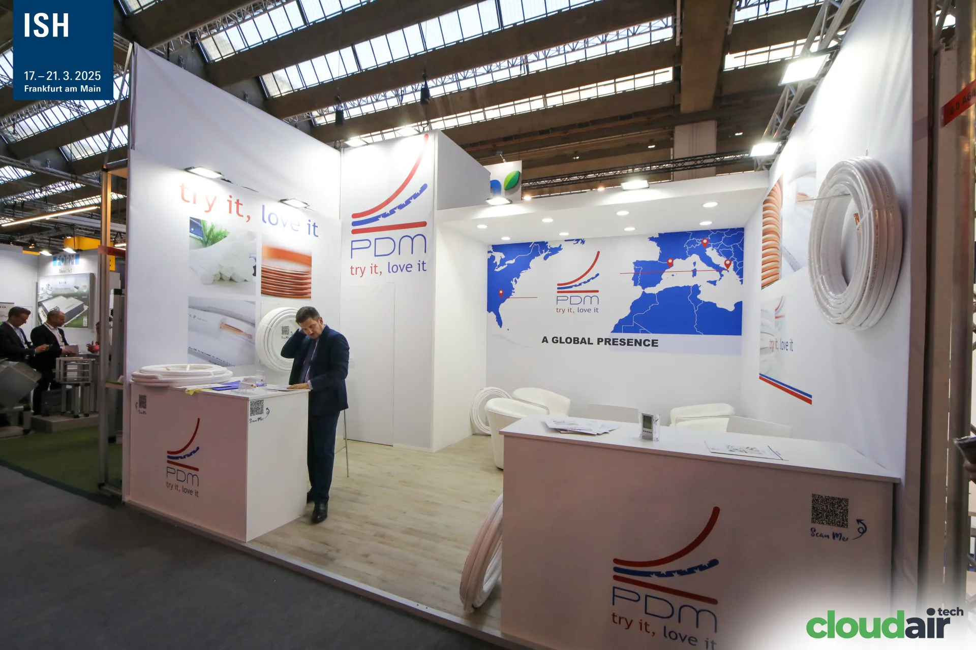 Wide view of the white PDM stand and its "A Global Presence" wall at ISH 2025