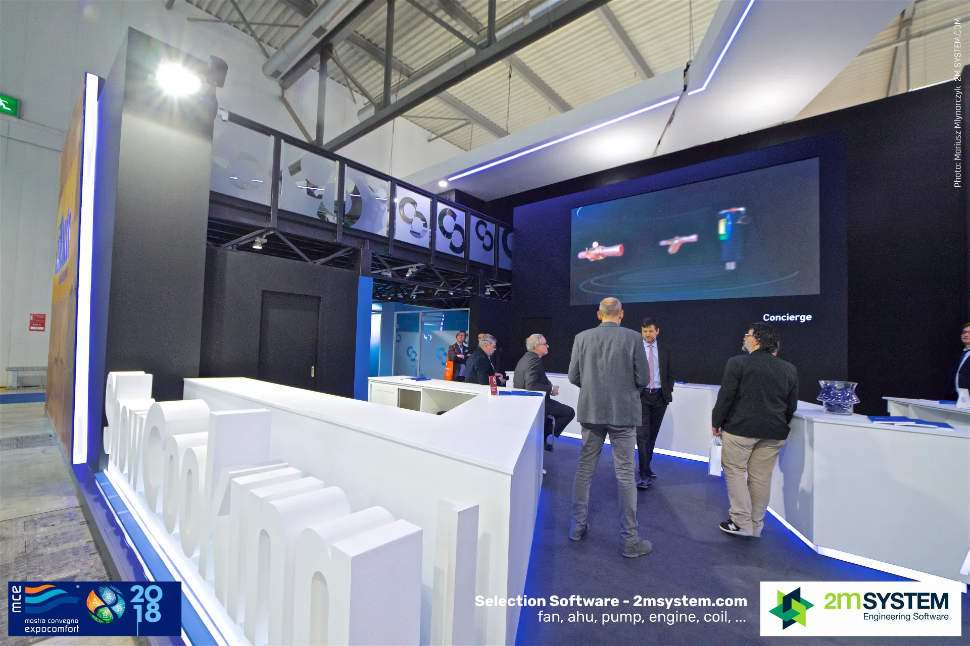 Castel two-storey stand with dark walls and 'Concierge' counter at MCE 2018