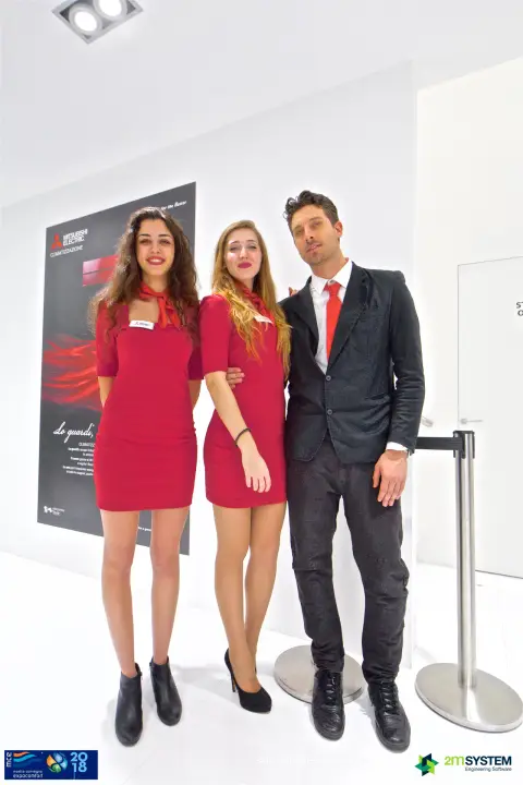 Closer vertical group photo of the Mitsubishi Electric stand team