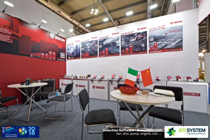 Hoocon actuator counters and poster wall behind a flag-topped meeting table at MCE 2018