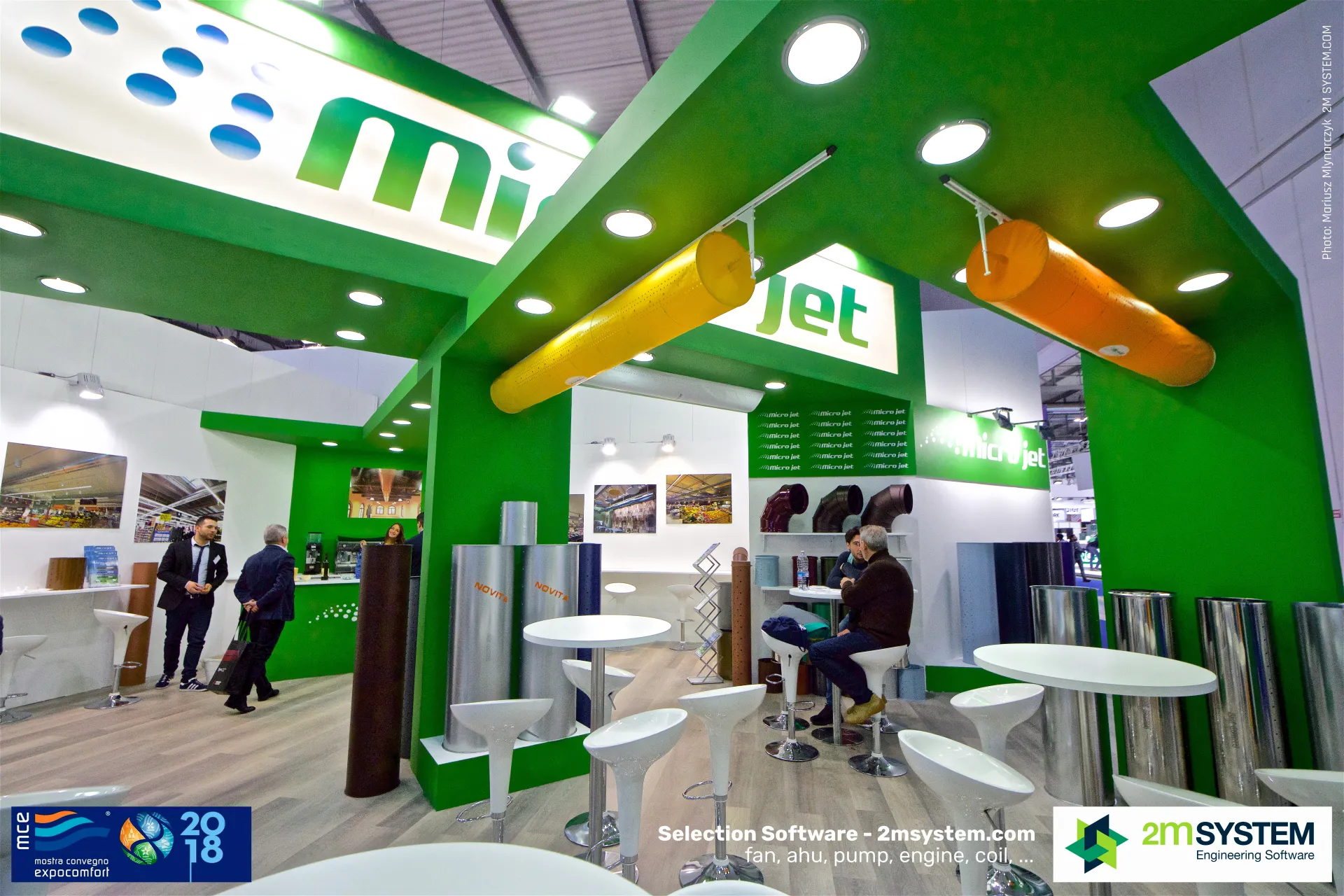 Micro Jet meeting area under suspended yellow and orange fabric ducts at MCE 2018