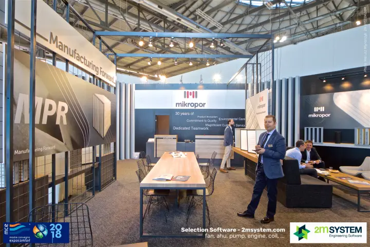 Mikropor stand with "Manufacturing Forward" sign and long wooden meeting table at MCE 2018