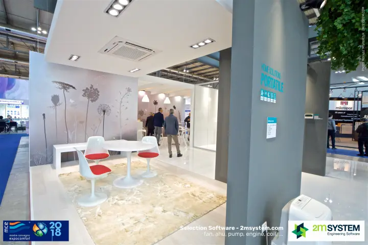 Portable air conditioner display beside a lounge corner with botanical mural