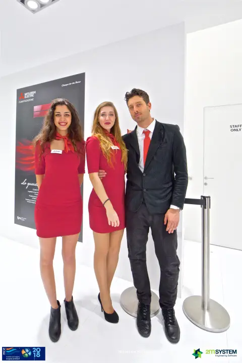 Portrait of the Mitsubishi Electric team in front of a split unit poster