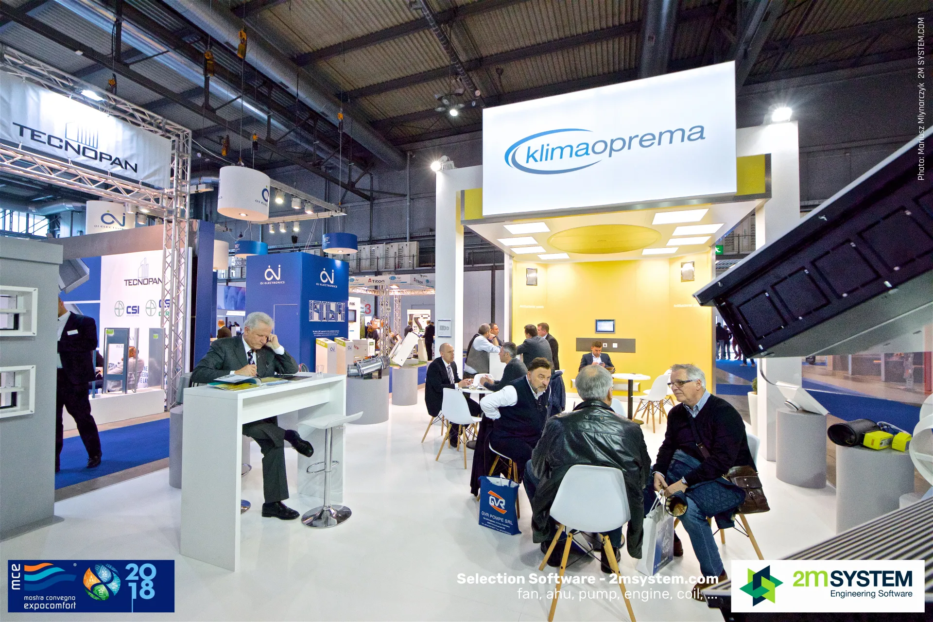 Visitors meeting at Klimaoprema tables under the illuminated logo box at MCE 2018