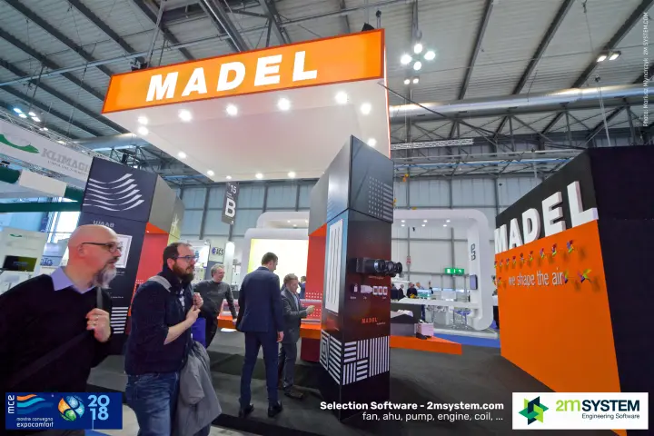 Visitors passing the Madel stand with its orange overhead sign
