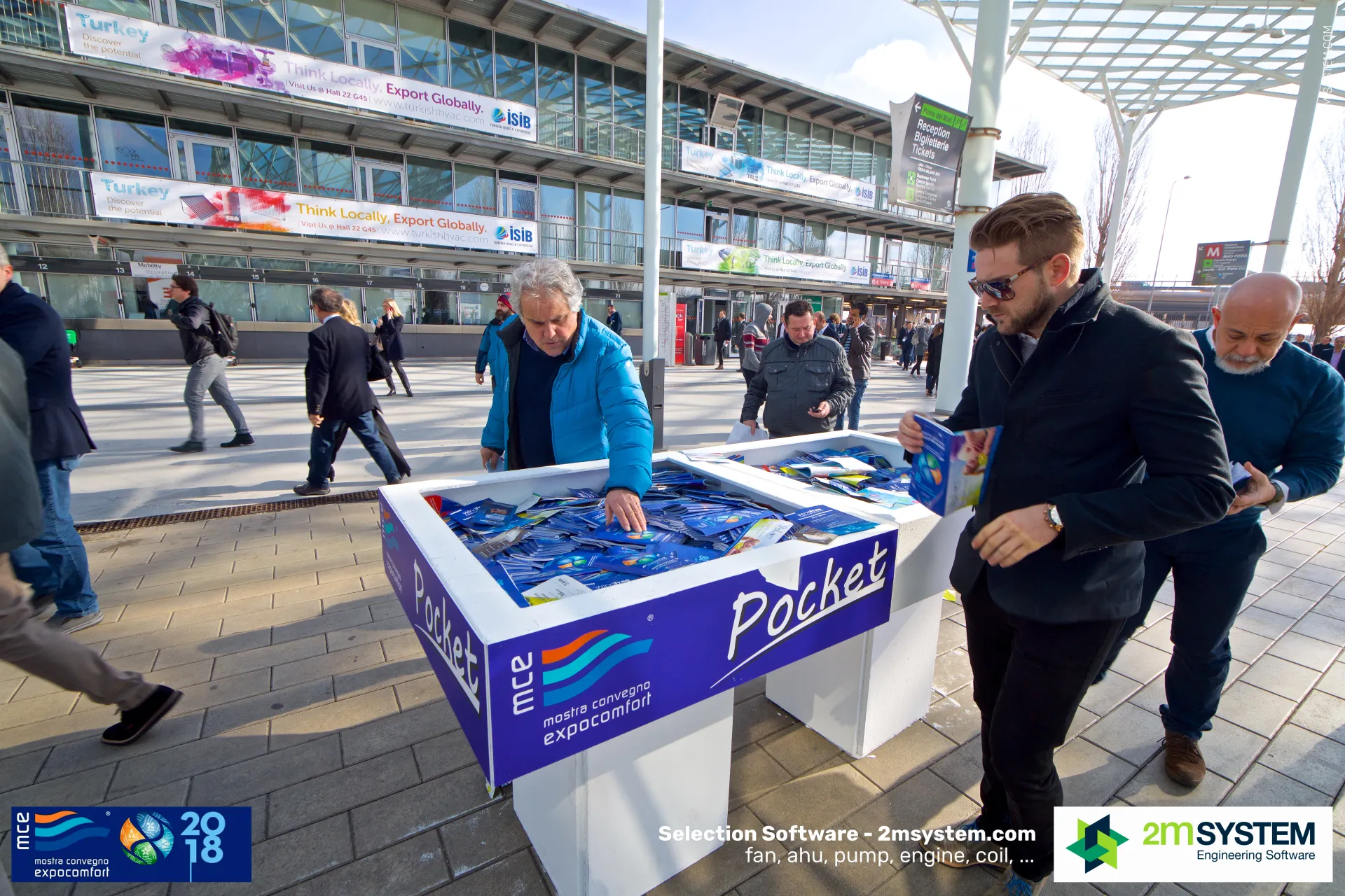 Visitors picking up free pocket guides from MCE 'Pocket' bins at the entrance at MCE 2018