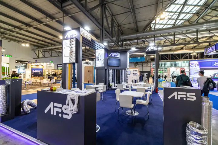 AFS stand with flexible aluminium ducts and navy meeting area at MCE 2024