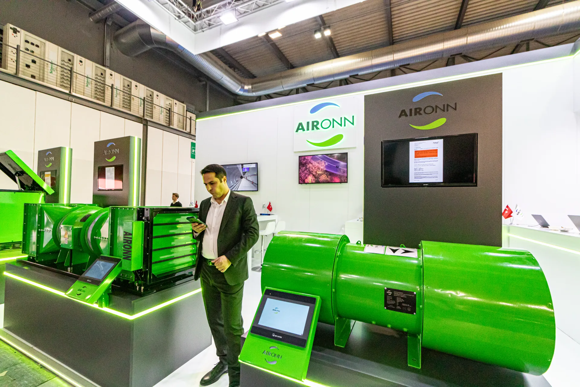 Aironn stand with green tubular fans and touchscreen product displays at MCE 2024