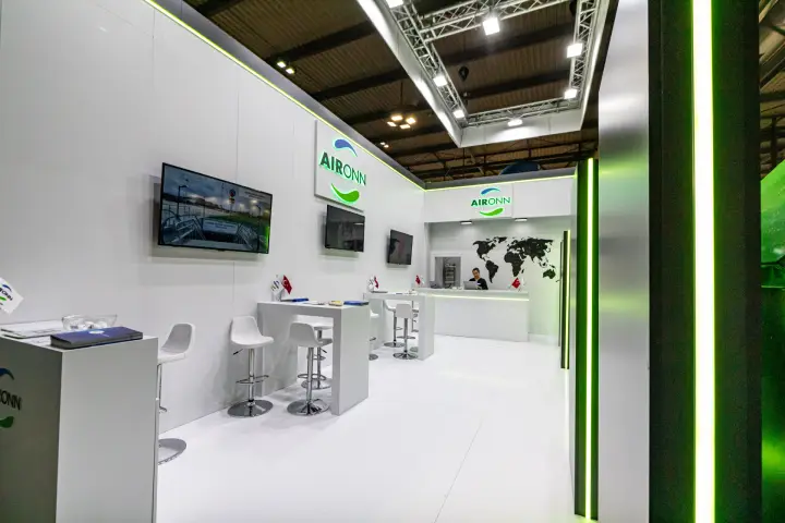 Aironn stand interior with reception desk and world map wall