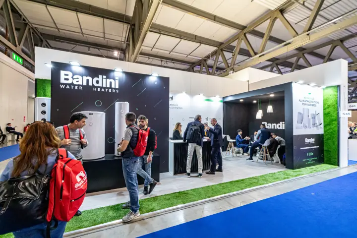 Bandini Water Heaters stand with black display wall and grass-edged floor