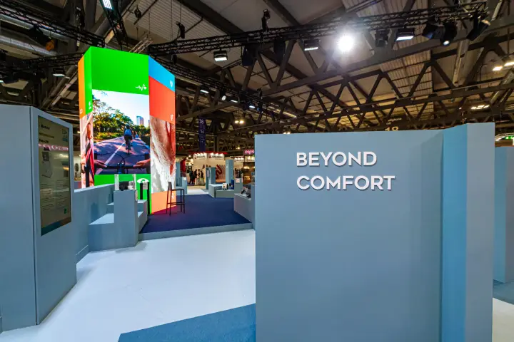 Beyond Comfort entrance with powder-blue walls and an LED video column at MCE 2024