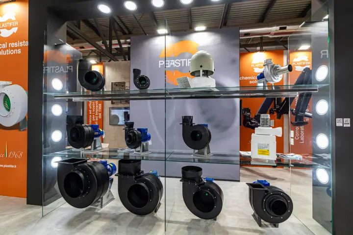 Black plastic centrifugal fans and a roof fan on Plastifer's glass display at MCE 2024