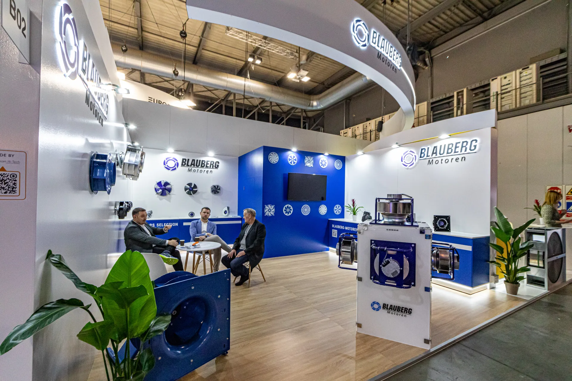 Blauberg Motoren stand with meeting table and curved illuminated fascia at MCE 2024
