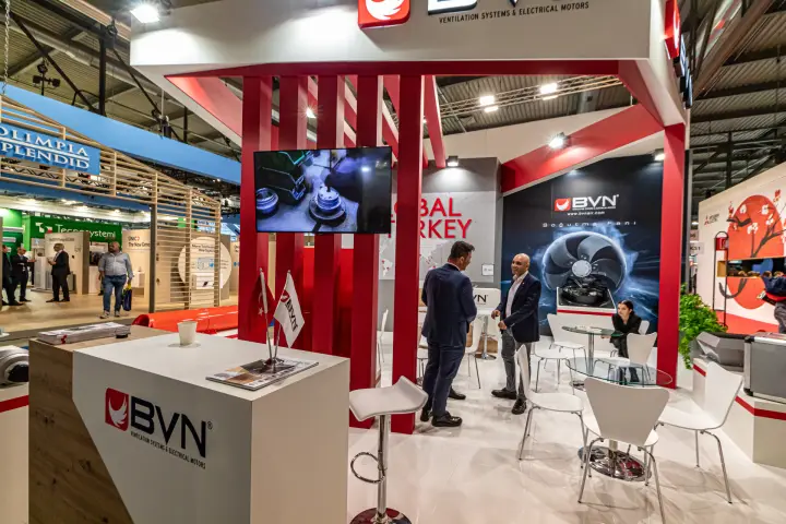 BVN counter with desk flags and machining footage on screen at MCE 2024