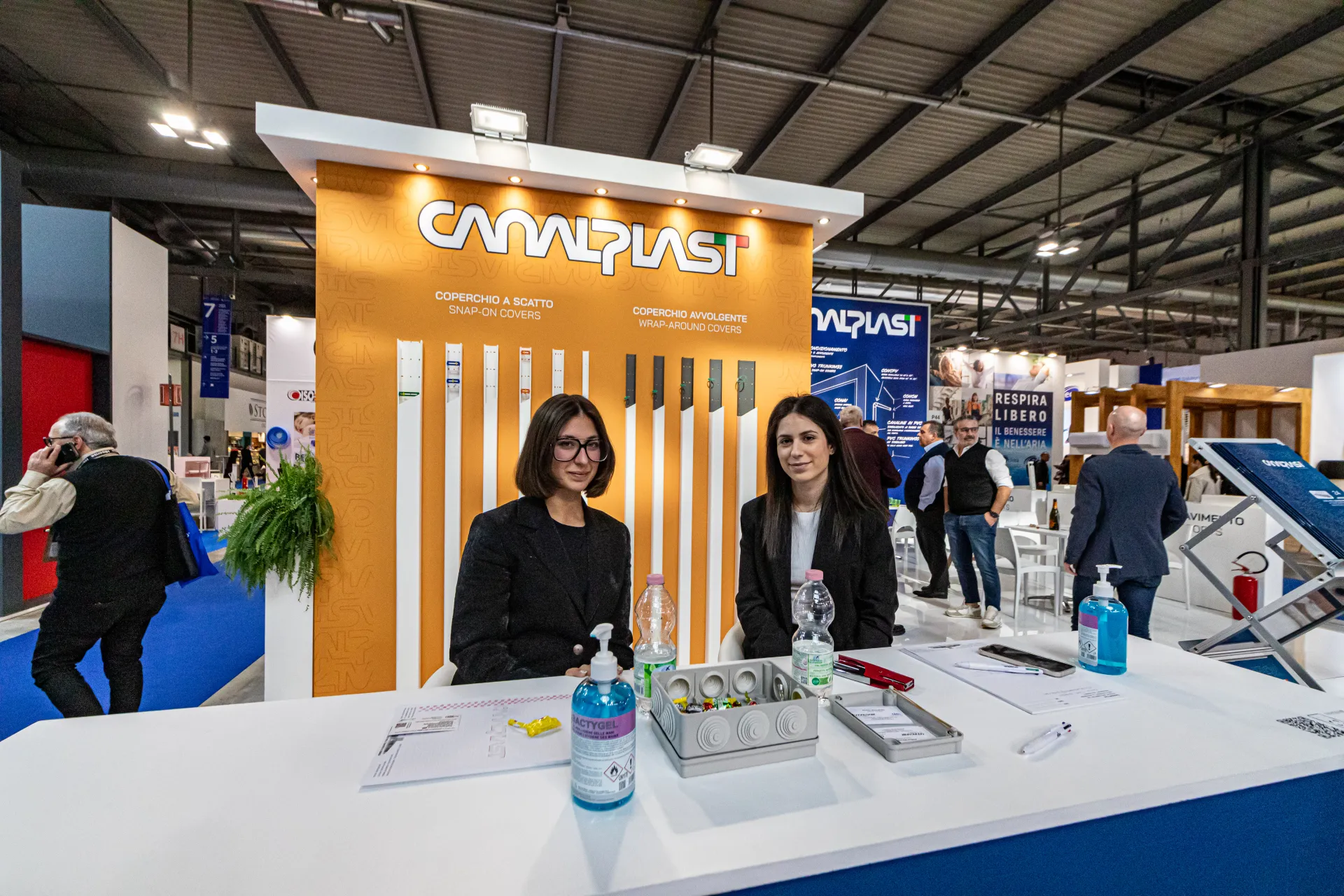 Canalplast reception desk in front of the orange trunking cover display at MCE 2024