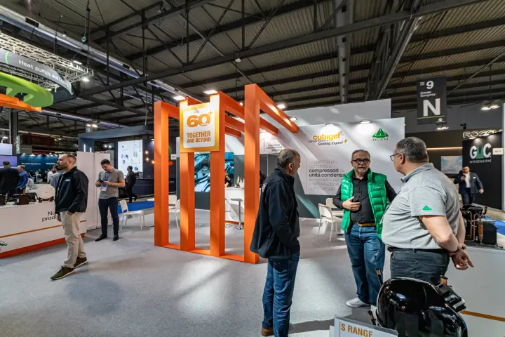 Cubigel stand with orange 60+ years frame and Italian product wall at MCE 2024