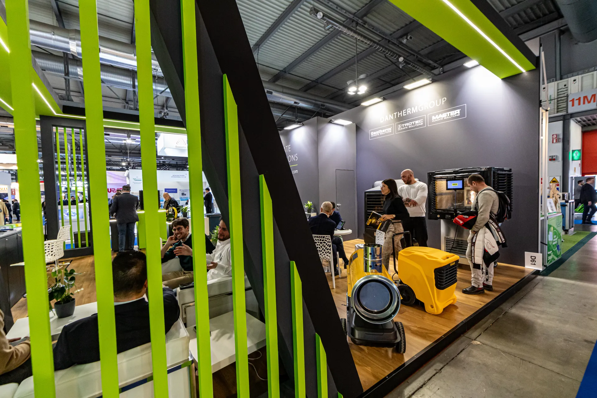 Dantherm Group stand with yellow portable units behind green slats at MCE 2024