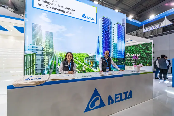 Delta Electronics reception counter with city skyline graphic and green wall at MCE 2024