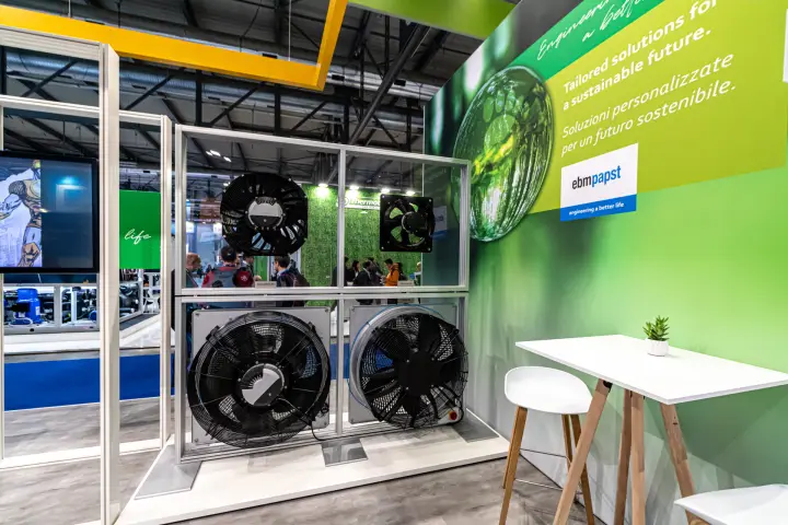 ebm-papst axial fans mounted in a frame beside a green sustainability wall at MCE 2024