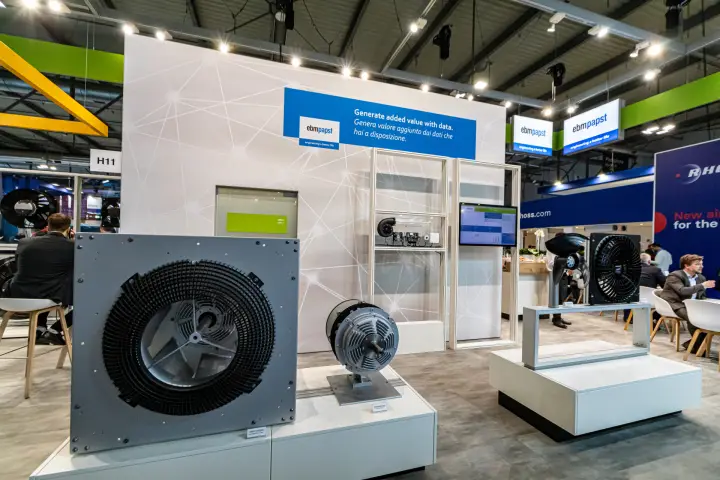 ebm-papst plug fan and motor display in front of the data-themed wall at MCE 2024