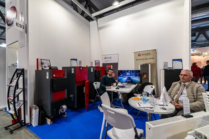 Enrad stand with red and grey boilers and pellet stove banner at MCE 2024
