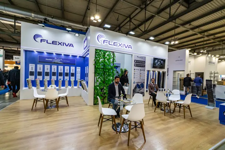 Flexiva stand with flexible duct rolls and a greenery-framed entrance
