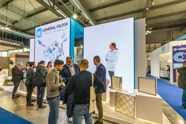 General Filter Italia panel filters on lit plinths beside LED video walls