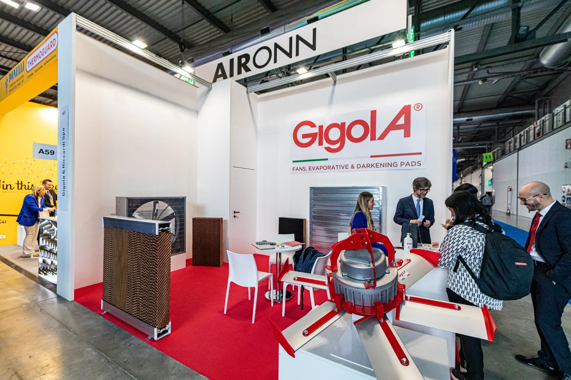 Gigola stand with large fans and evaporative cooling pads at MCE 2024