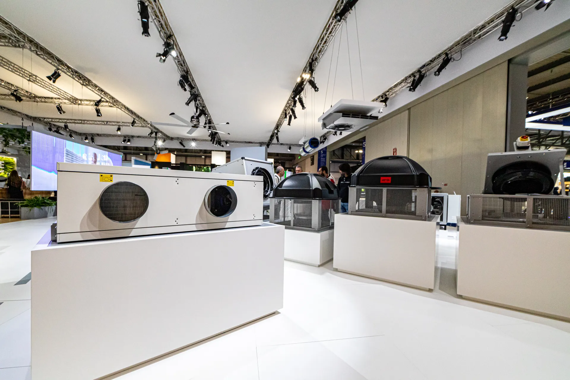 Heat recovery unit and black-domed roof fans on white plinths at MCE 2024