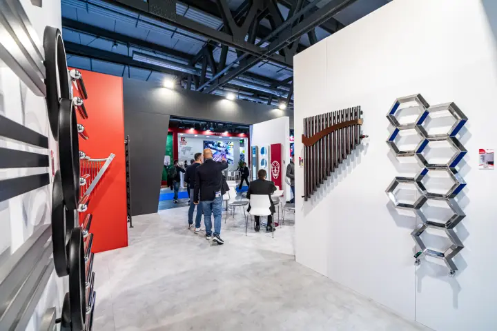 Hexagon chrome radiator and bar radiator with a wooden curve on a white wall at MCE 2024