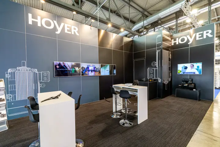 Hoyer stand with motor line drawings and video screens at MCE 2024