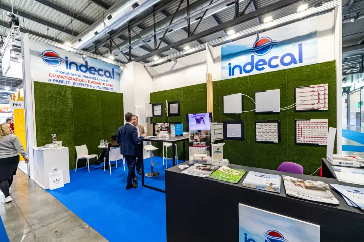 Indecal stand with radiant panel samples on artificial grass walls