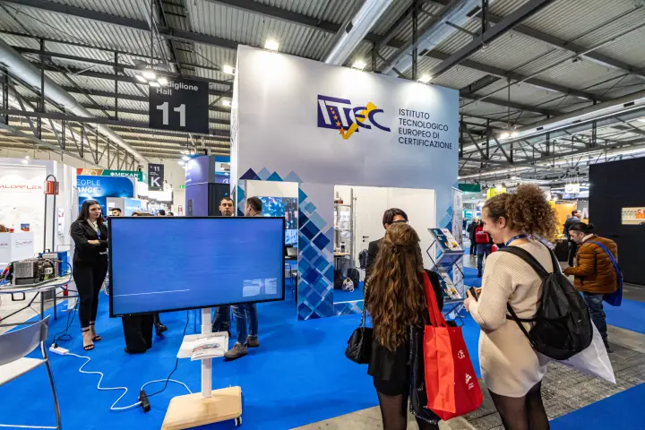 ITEC stand tower with blue mosaic graphics and a display screen at MCE 2024