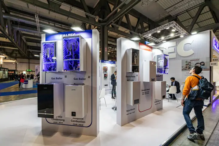 Kaltec gas boilers with open casings lit in blue at the stand corner