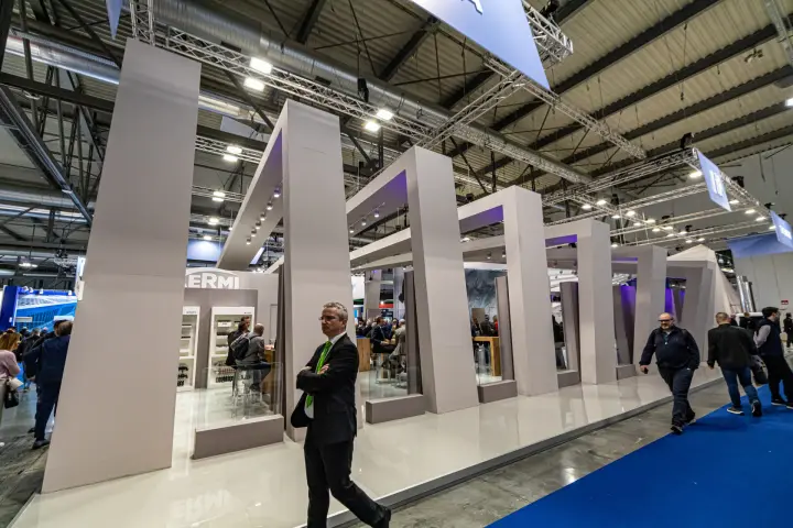 Kermi stand facade of tilted grey portal frames with violet lighting