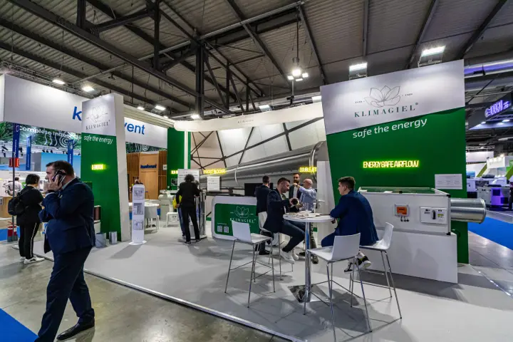 Klimagiel stand with neon signs and a large metal air duct