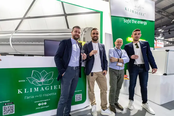 Klimagiel team toasting beside the stand counter and air duct