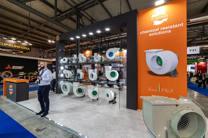Large plastic centrifugal fan in front of Plastifer's orange slogan column at MCE 2024