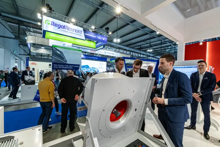 Large white centrifugal fan with red impeller examined by visitors at MCE 2024