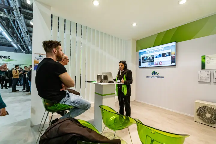 Masterclima software presentation with wall screen and green chairs at MCE 2024