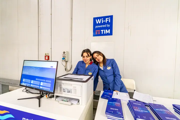 MCE info desk with Wi-Fi powered by TIM sign and pocket guides